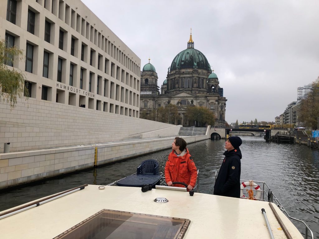 Hausboot in Vorbeifahrt an der modernen Fassade des Humboldt-Forums.